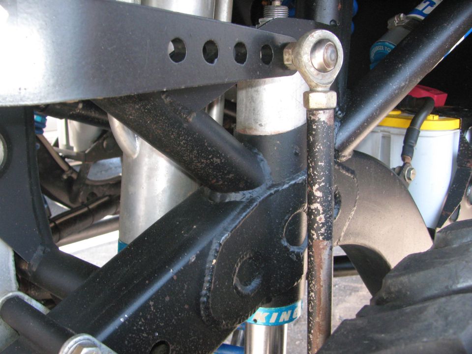 Close-up of off-road suspension link, rod end, shock and exhaust pipe routing