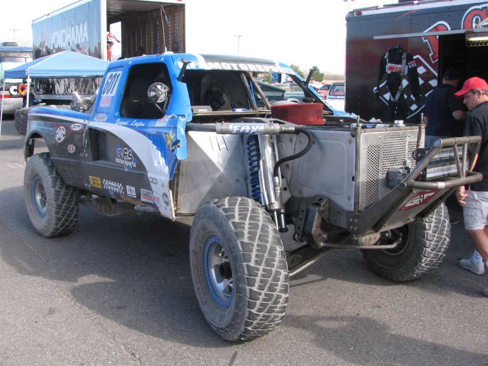 Blue and gray number 601 off-road race truck rear quarter showing bed and shocks