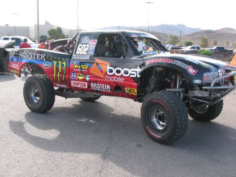 1990 Ford Bronco - Front three-quarter view of a number 602 off-road trophy truck with Monster Energy, Boost Mobile and Bilstein graphics and General Tire tir…