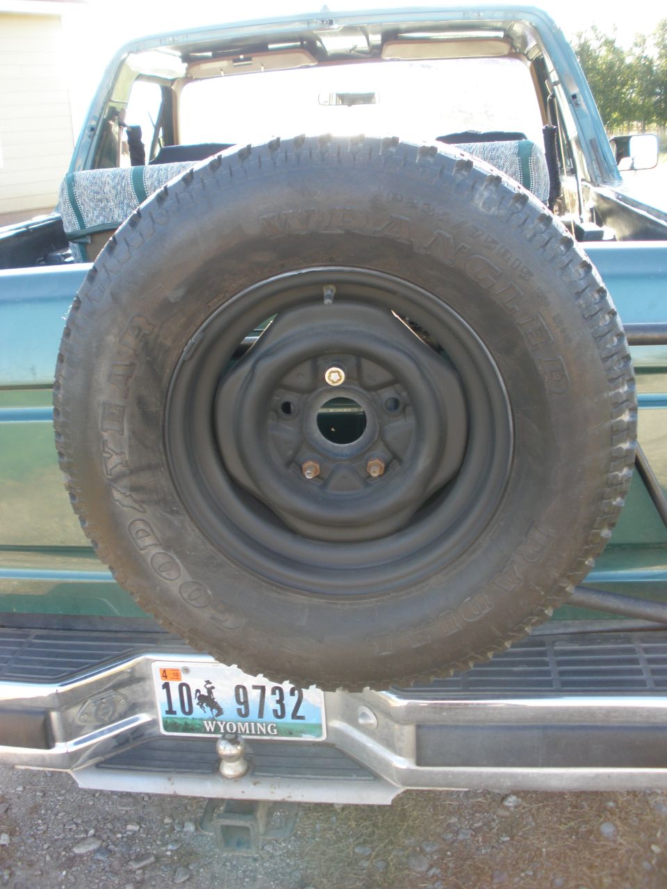 Spare tire on rear of green SUV with Wyoming license plate