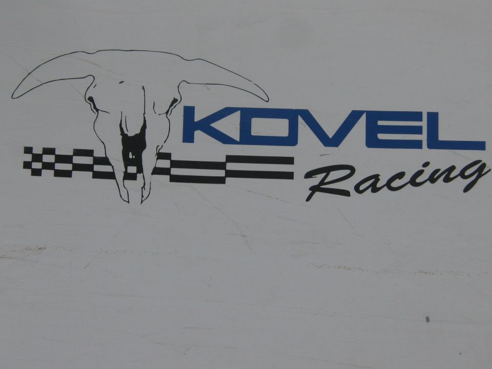 Kovel Racing logo with longhorn skull and checkered flags on white panel