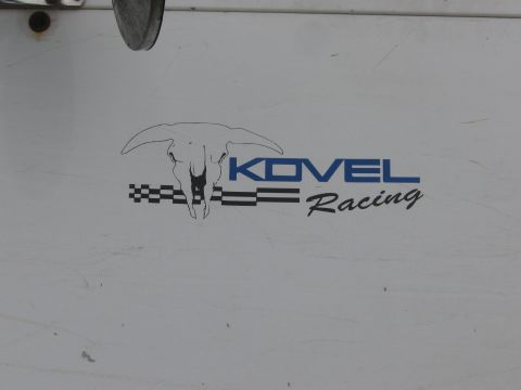 1990 Ford Bronco - Close-up of the Kovel Racing logo with its longhorn skull and checkered stripes on a scuffed white surface.