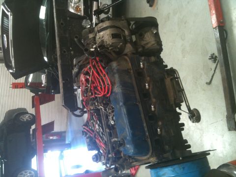 1990 Ford C-150 (Centurion Conversions) - Engine assembly undergoing work, showing red spark plug wires and blue valve covers.