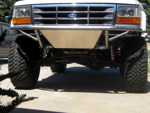 1996 Ford Bronco - Close-up view of the front bumper and suspension of a modified Ford truck.