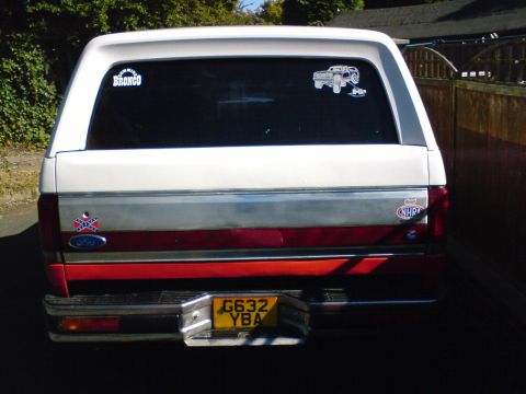 1989 Ford Bronco - Rear view of a 1989 Ford Bronco, showing stickers and license plate.