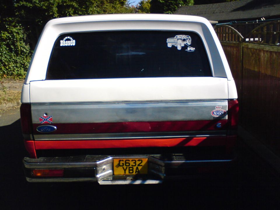 1989 Ford Bronco rear with two stickers on the window and a license plate