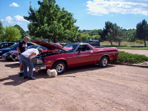 1972 Ford Ranchero - Two men examine the engine of a red 1972 Ford Ranchero at an outdoor gathering.