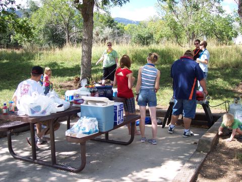 1972 Ford Ranchero - A group of people enjoy a picnic outdoors, with food and coolers on tables.