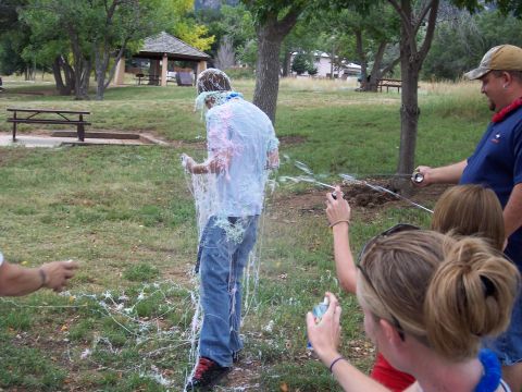 1972 Ford Ranchero - A group of people are having fun at a park, spraying silly string at one another.