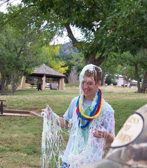 1972 Ford Ranchero - A young man is covered in streamers and leis after a celebration in a park setting.