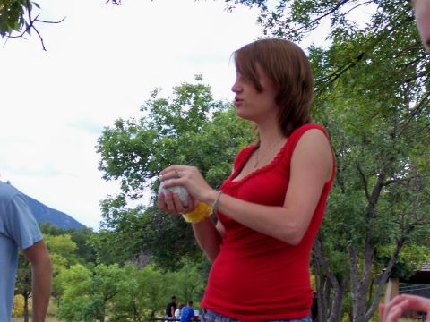 1972 Ford Ranchero - A woman in a red shirt holds a ball while standing outdoors with trees and a mountain in the background.