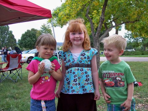 1972 Ford Ranchero - Three children pose for a photo at an outdoor event, with cars visible in the background under a red canopy.