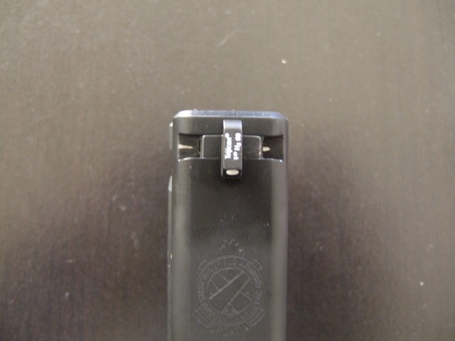 Rear sight of a black handgun with white dots and text 'Trijicon PP HG 08'