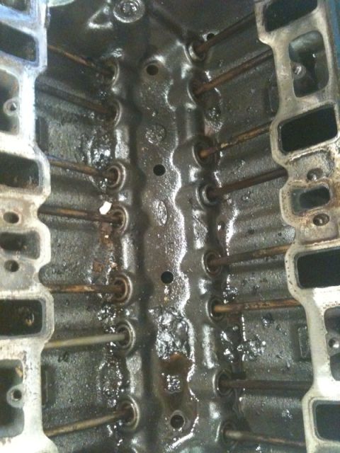 1990 Ford C-150 (Centurion Conversions) - Close-up view of an engine block's internal components, showing pushrods and signs of oil. Watermark present.