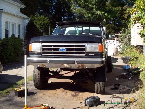 1989 Ford F-150 - This 1989 Ford F-150 pickup truck is shown from the front, a lifted suspension and 4x4 badging.
