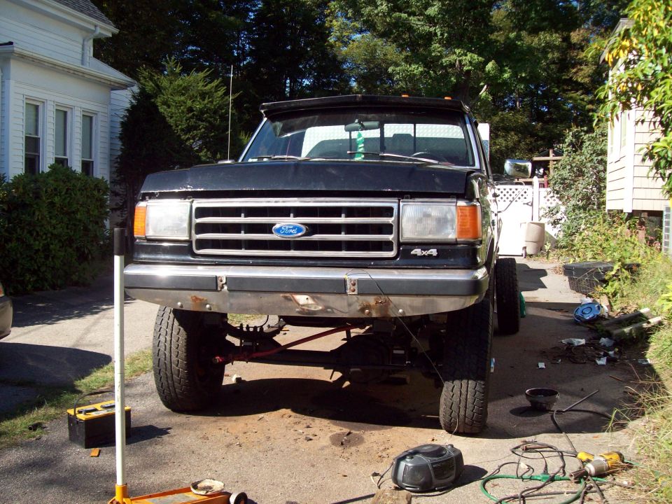 Front view of a black 1989 Ford F-150 pickup truck with a lifted suspension