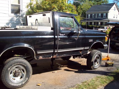 1989 Ford F-150 - This black 1989 Ford F-150 pickup truck is shown with a toolbox in the bed and appears to be undergoing some work.