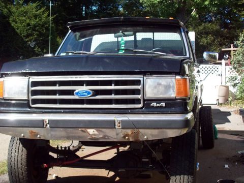 1989 Ford F-150 - This 1989 Ford F-150 pickup truck is shown from the front, its distinctive grille and 4x4 badging.