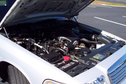 2001 Ford Crown Victoria - The engine bay of a 2001 Ford Crown Victoria is visible with the hood raised, revealing the engine components.