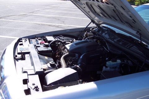 2001 Ford Crown Victoria - The engine compartment of a 2003 Ford Crown Victoria is visible with the hood open, revealing the engine and associated parts.