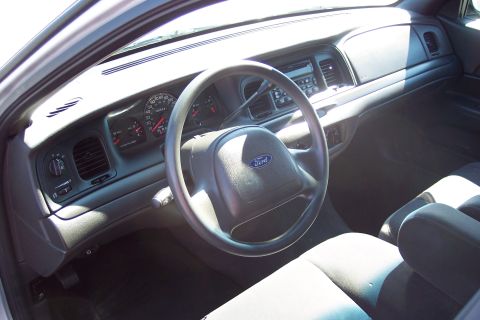 2001 Ford Crown Victoria - The interior of a 2001 Ford Crown Victoria, viewed from the passenger side, reveals the dashboard, steering wheel, and seats.