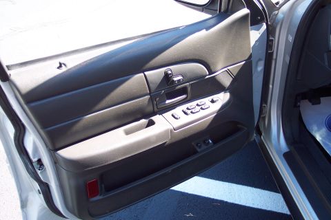 2001 Ford Crown Victoria - Close-up of the interior door panel, showing the power window controls and a storage compartment.