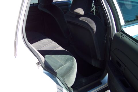 2001 Ford Crown Victoria - Rear interior view of a white vehicle, showing the back seats and door panel.