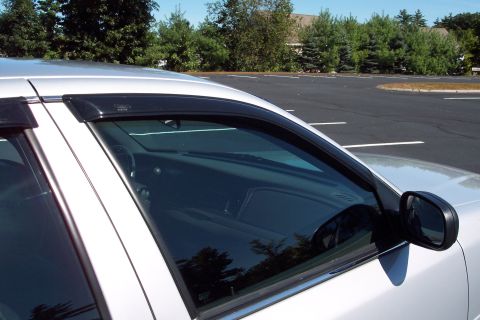 2001 Ford Crown Victoria - A silver 2001 Ford Crown Victoria is parked in a lot, showing its side profile and window visors.