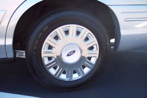 2001 Ford Crown Victoria - A close-up of a silver 2003 Ford Crown Victoria's wheel and side panel.