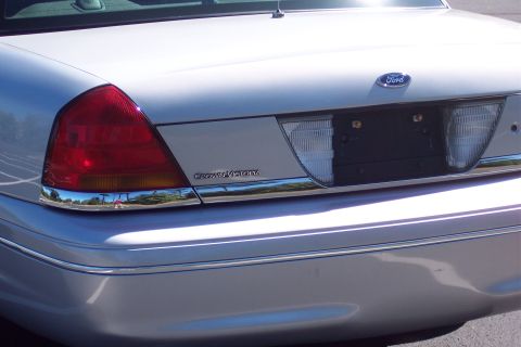 2001 Ford Crown Victoria - The rear of a white Ford Crown Victoria shows its distinctive taillight and chrome detailing.