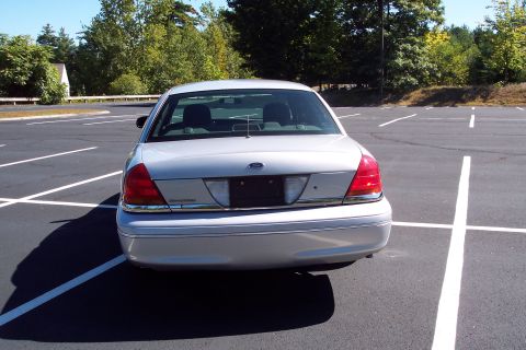 2001 Ford Crown Victoria - Rear view of a silver 2001 Ford Crown Victoria parked in an empty lot.
