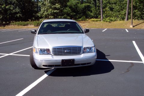2001 Ford Crown Victoria - Front view of a silver 2001 Ford Crown Victoria parked in a lot.
