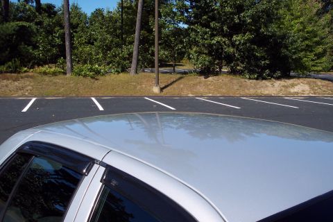 2001 Ford Crown Victoria - A silver 2001 Ford Crown Victoria is seen from a high angle, focusing on its roof and side window.