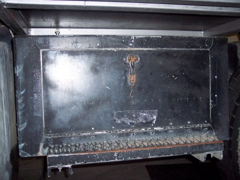 1981 Kenworth W900A - Close-up of a black metal storage compartment on the side of a truck, a latch and a textured step below.