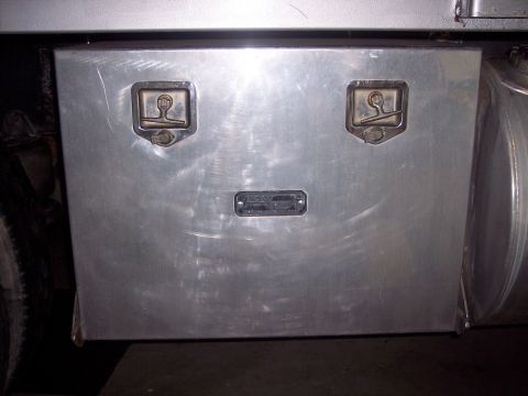 1981 Kenworth W900A - Detail of an aluminum tool box mounted on a truck, two prominent latches and a central plate.