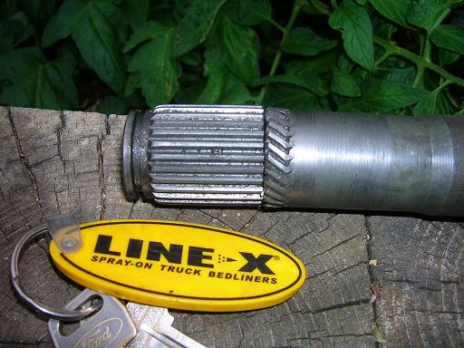 Metal shaft with splines and a yellow LINE-X keychain. Ford keys are also visible