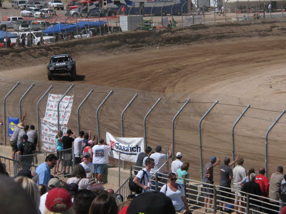 Off-road race truck kicking up dust on a dirt track with a BFGoodrich banner