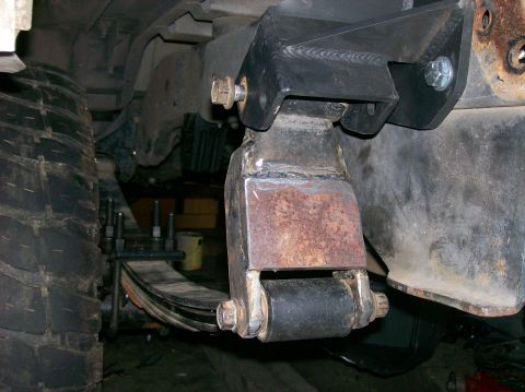 1989 Ford Bronco - Custom suspension bracketry is shown attached to the leaf springs and frame of a vehicle.