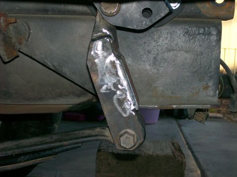1989 Ford Bronco - Close-up of a welded bracket attached to a vehicle's frame, with a bolt clearly marked '98'.