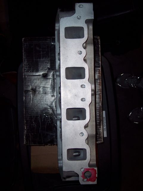 1971 Ford Mustang - Close-up of an aluminum engine cylinder head, showing intake ports and an 'OIL SYSTEM' label.