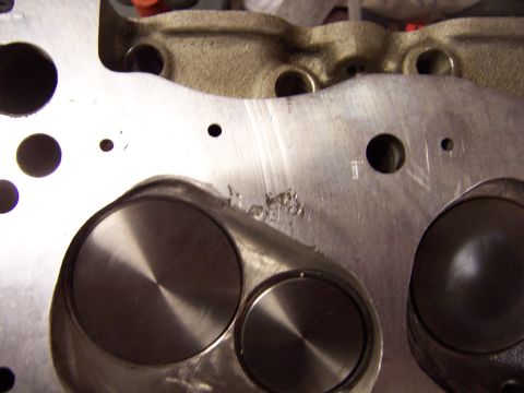 1971 Ford Mustang - Close-up view of an engine cylinder head, revealing two valves and some surface damage.