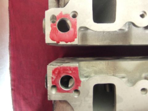 1971 Ford Mustang - Close-up of two engine cylinder heads, showing red sealant applied to bolt holes.
