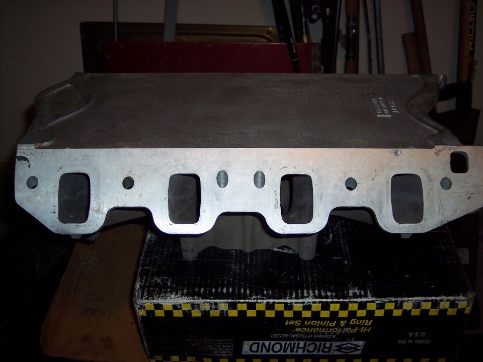 Aluminum intake manifold with four intake ports on each side, resting on a Richmond box