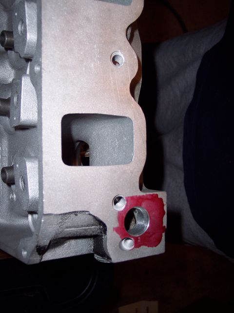 1971 Ford Mustang - A close-up view of an engine cylinder head, showing a bolt hole with red sealant applied.