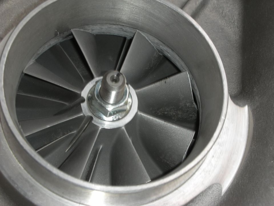 Close-up of a turbocharger compressor wheel with angled blades