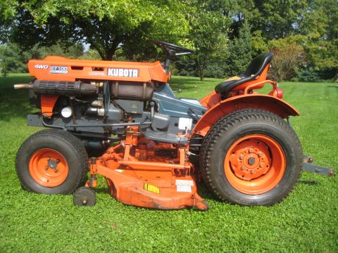 1993 Ford Probe - This orange Kubota tractor, identified as a 4WD B7100 model, is shown from a three-quarter front view on a grassy lawn.