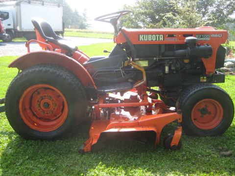 1993 Ford Probe - This orange Kubota tractor is equipped with a mower deck and is shown from a side angle.