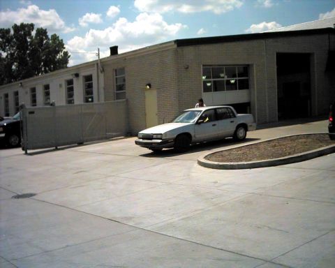 1990 Ford Taurus - A white 1990 Ford Taurus sedan is seen from a 3q-front angle in front of a brick building.