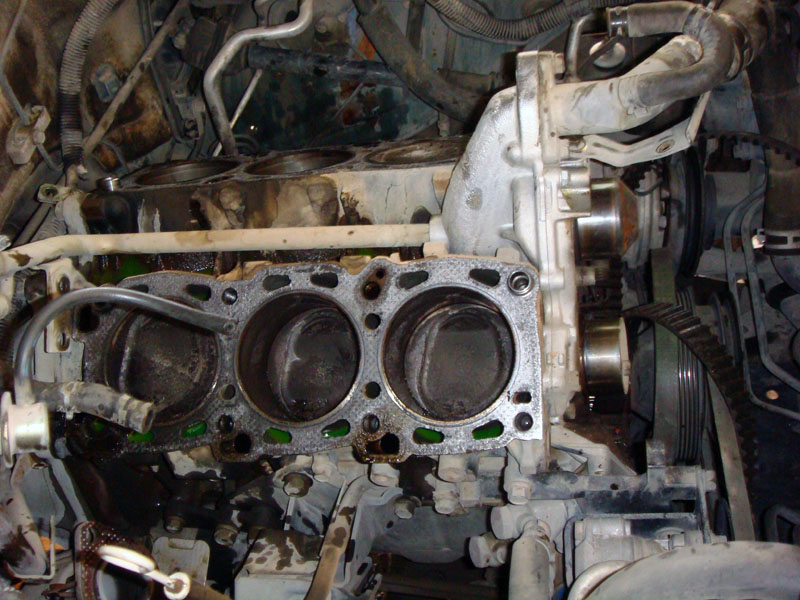 Engine block with pistons exposed, timing belt visible