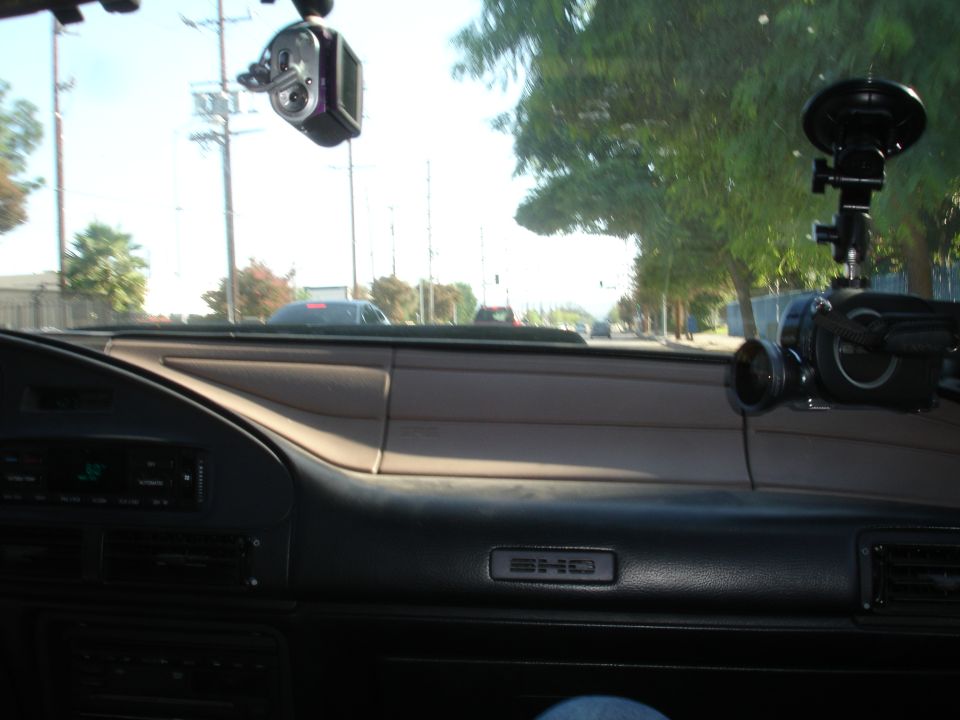Dashboard of a 1993 Ford Taurus with two camera mounts attached to the windshield and passenger side